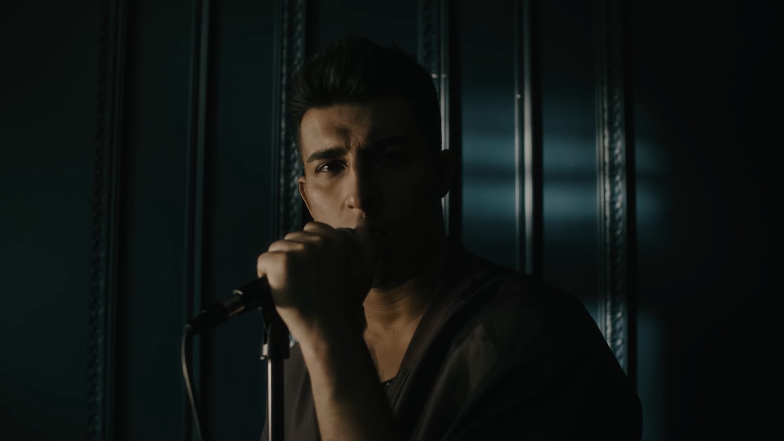 Cool low-key portrait, singer at the microphone